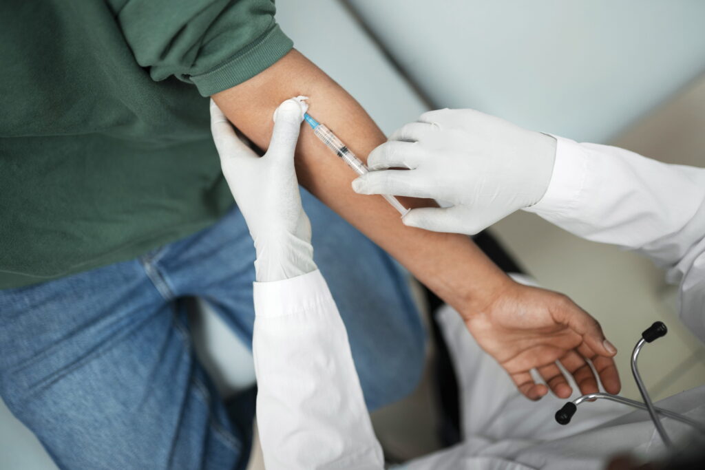 Close up of a nurse drawing blood from a man’s arm