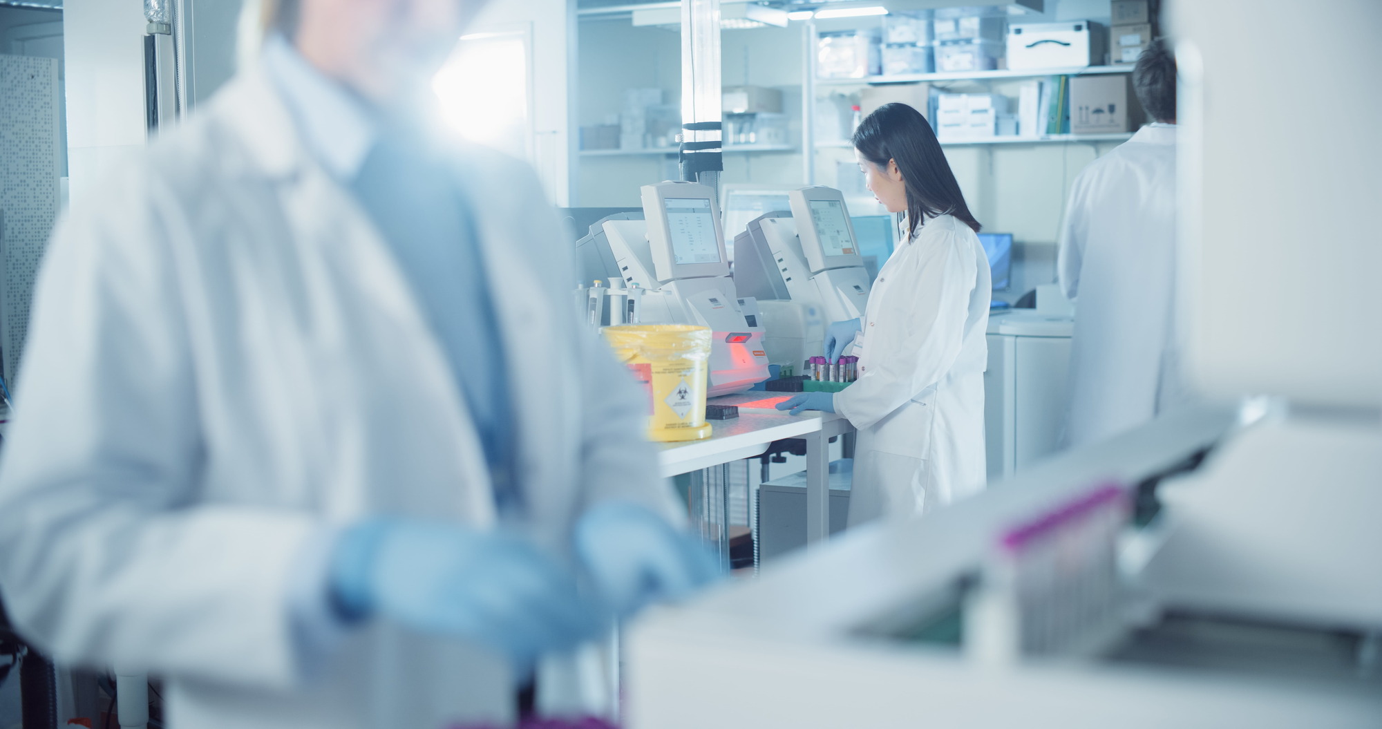Healthcare professionals working in a diagnostic laboratory with working equipment.