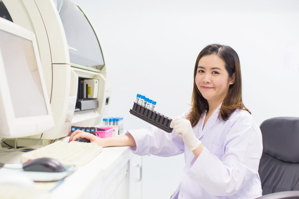 Medical technologist holding a sample while writing down the results of a test.