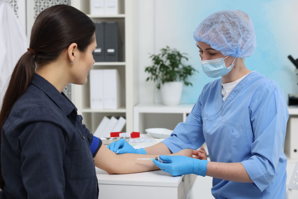 A medical professional preparing to draw a blood sample from a patient.
